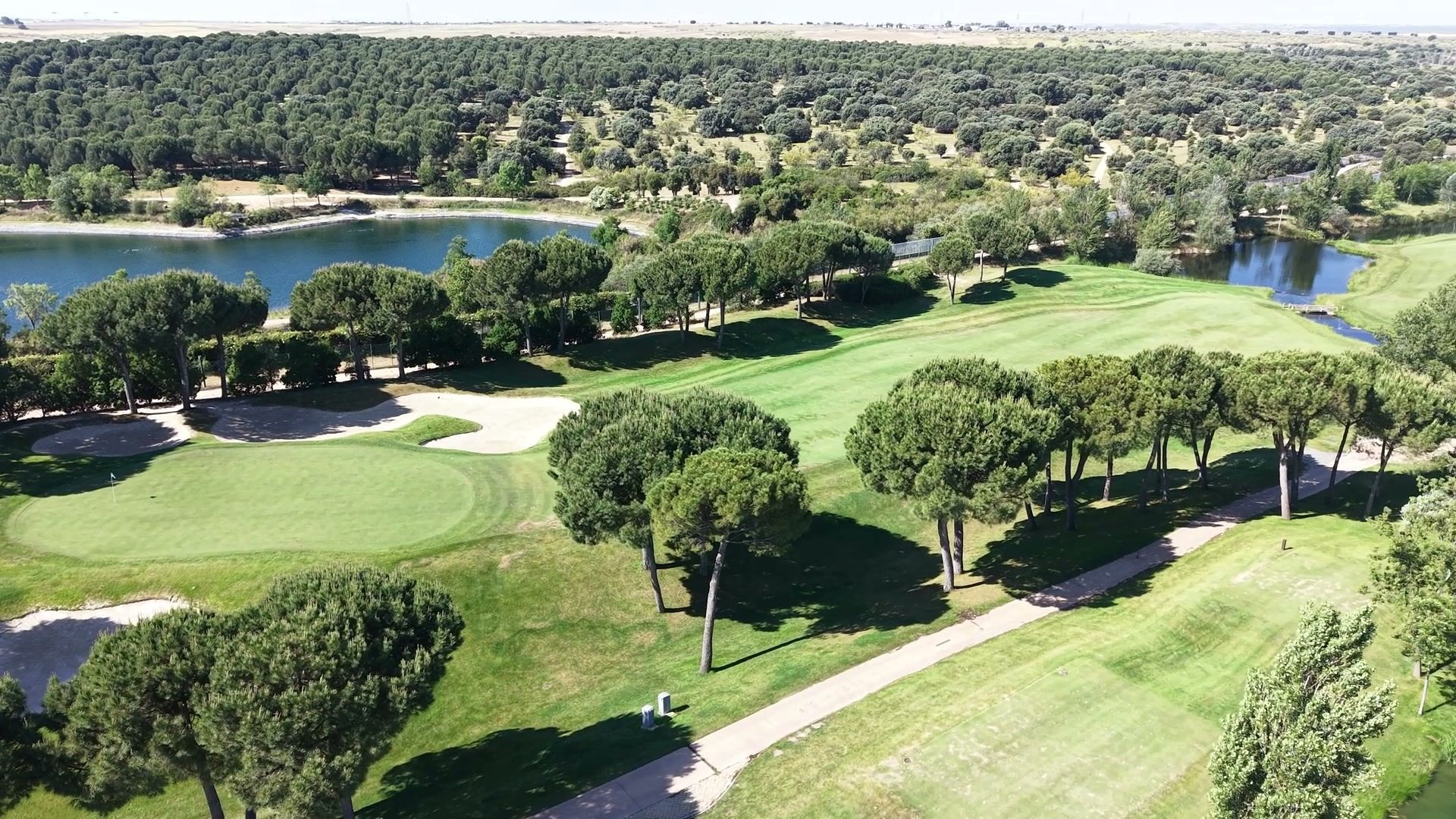 Lago, pinos y green del campo de golf de la Ciudad Financiera, visto desde el dron